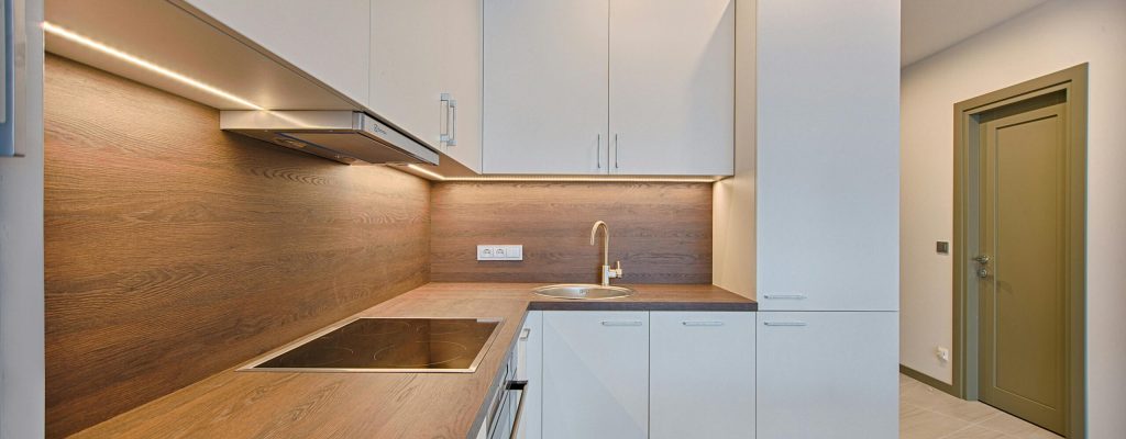 Modern kitchen interior with minimalistic design and wooden accents, captured with natural lighting.
