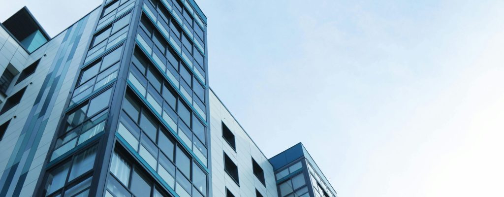 Low-angle view of a modern glass skyscraper against a clear sky in Poole, UK.